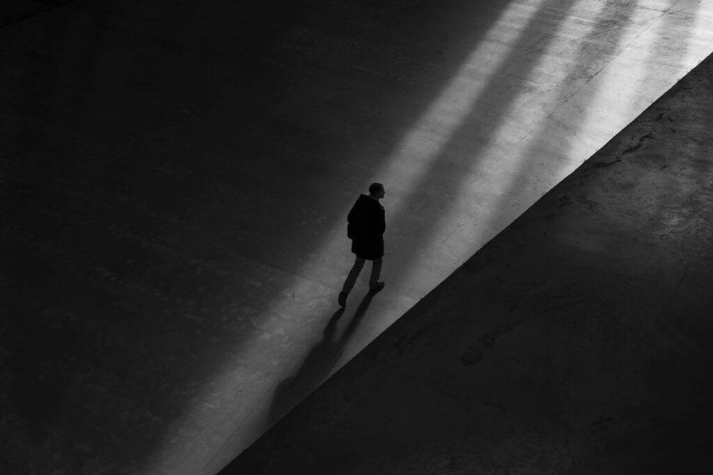 Image of a man walking through shadows symbolising the loneliness of being avoidant attached
