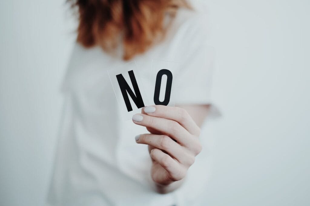 Woman holding up the letters no, inner child therapy for avoidant attachment