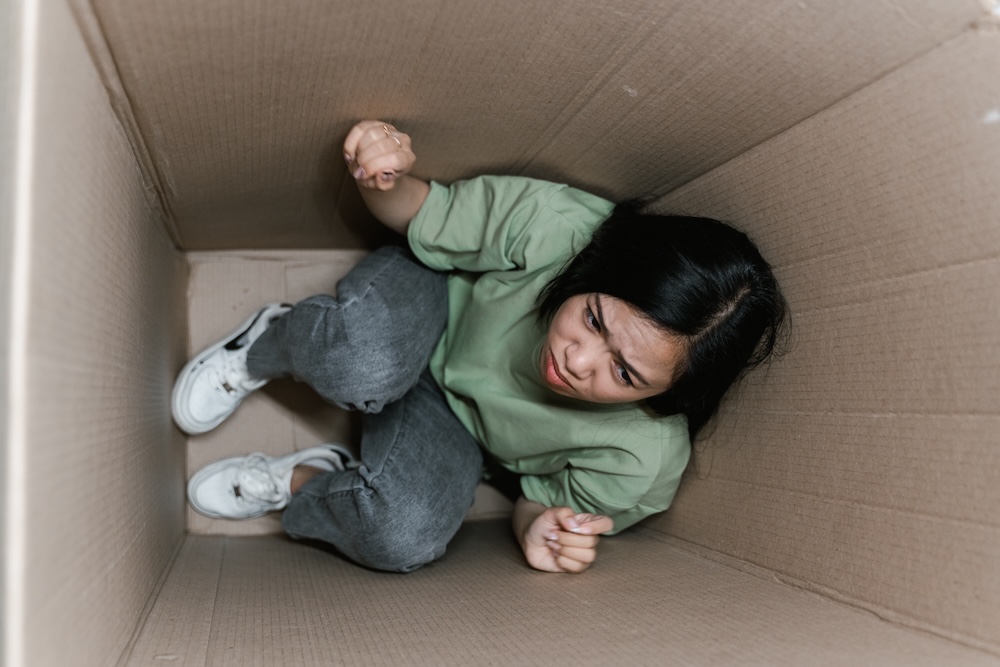 Image of a woman in a box looking trapped, anxiety hypnotherapy with Rowenna