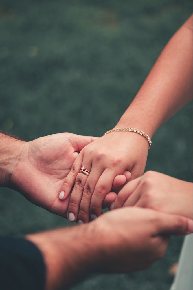 Image of two people holding hands, avoidant attachment hypnotherapy with Rowenna