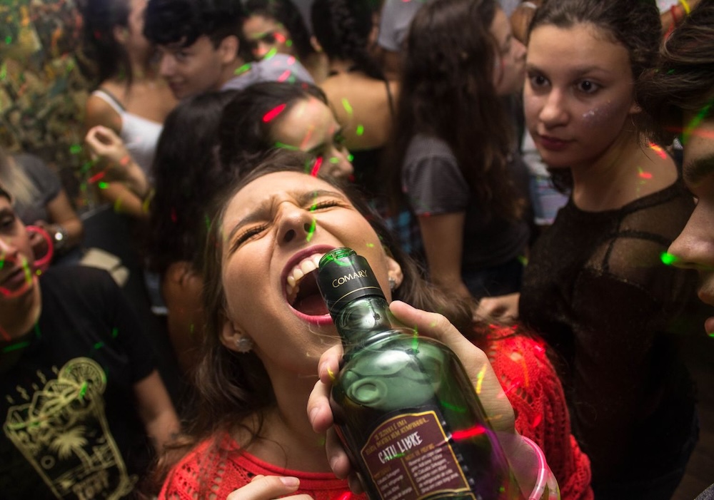 Image of a woman having alcohol poured into her mouth at a party, complex trauma and vulnerability blog by Rowenna