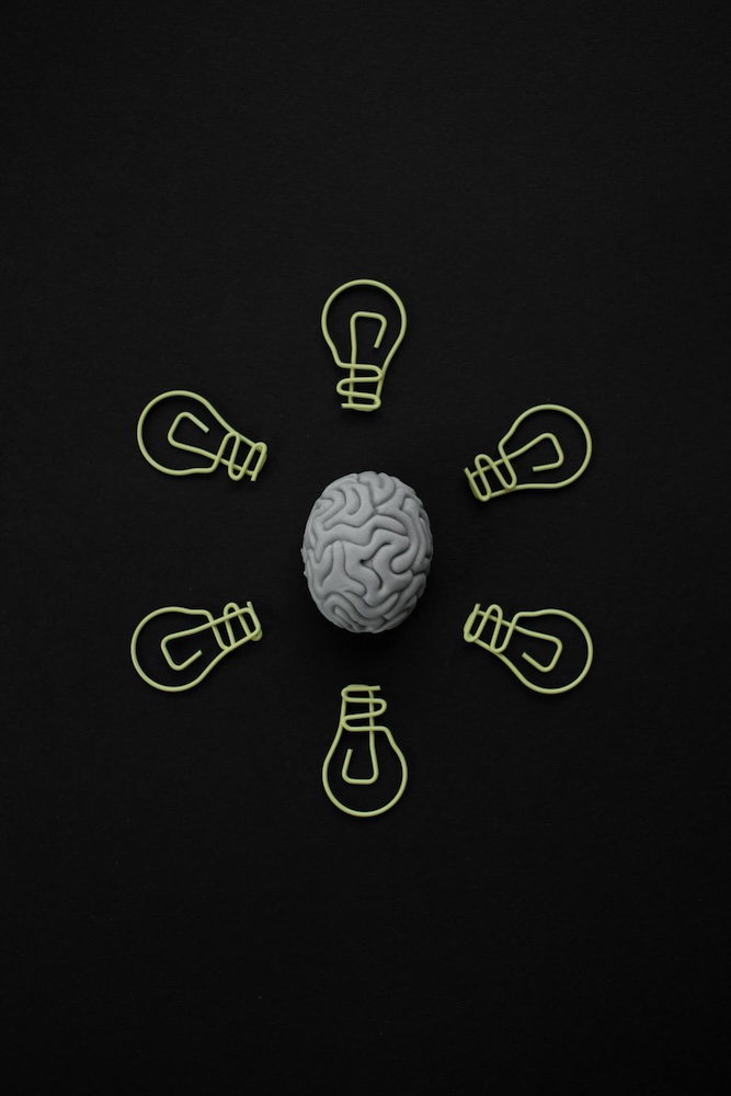 drawing of a brain with lightbulbs around it. NLP coaching with Rowenna