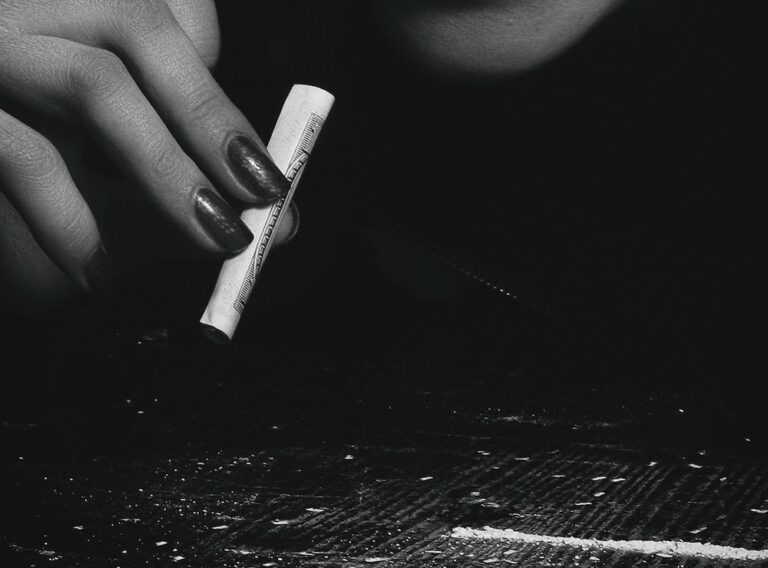 Image of a woman with a rolled up note and a line of powder on the table, hypnosis for addiction with Rowenna Clifford