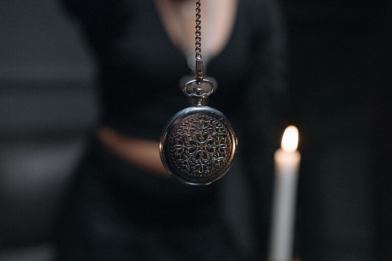 Image of a woman swimming a watch in front of a candle, myths about hypnotherapy