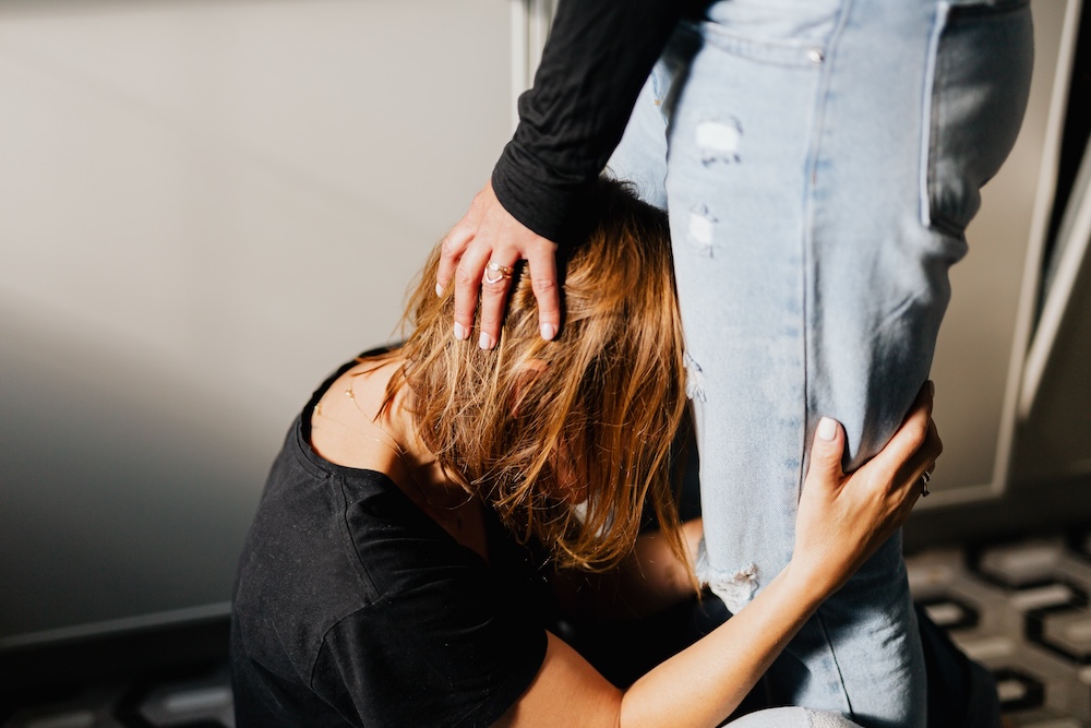 Image of a woman clinging on to her partner by their legs, what is codependency blog by Rowenna