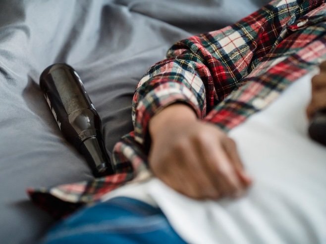Image of a man laying down with empty beer bottles around him, stop drinking hypnotherapy london with Rowenna Clifford